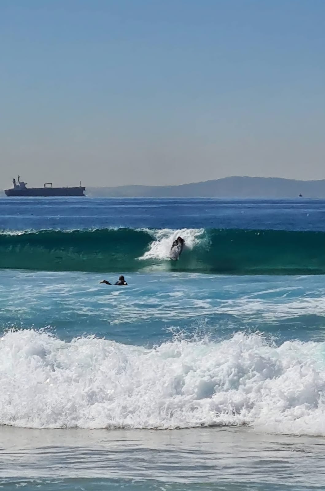 Surfer auf einer Welle an einem Beachbreak in Tarifa nahe dem Haus
