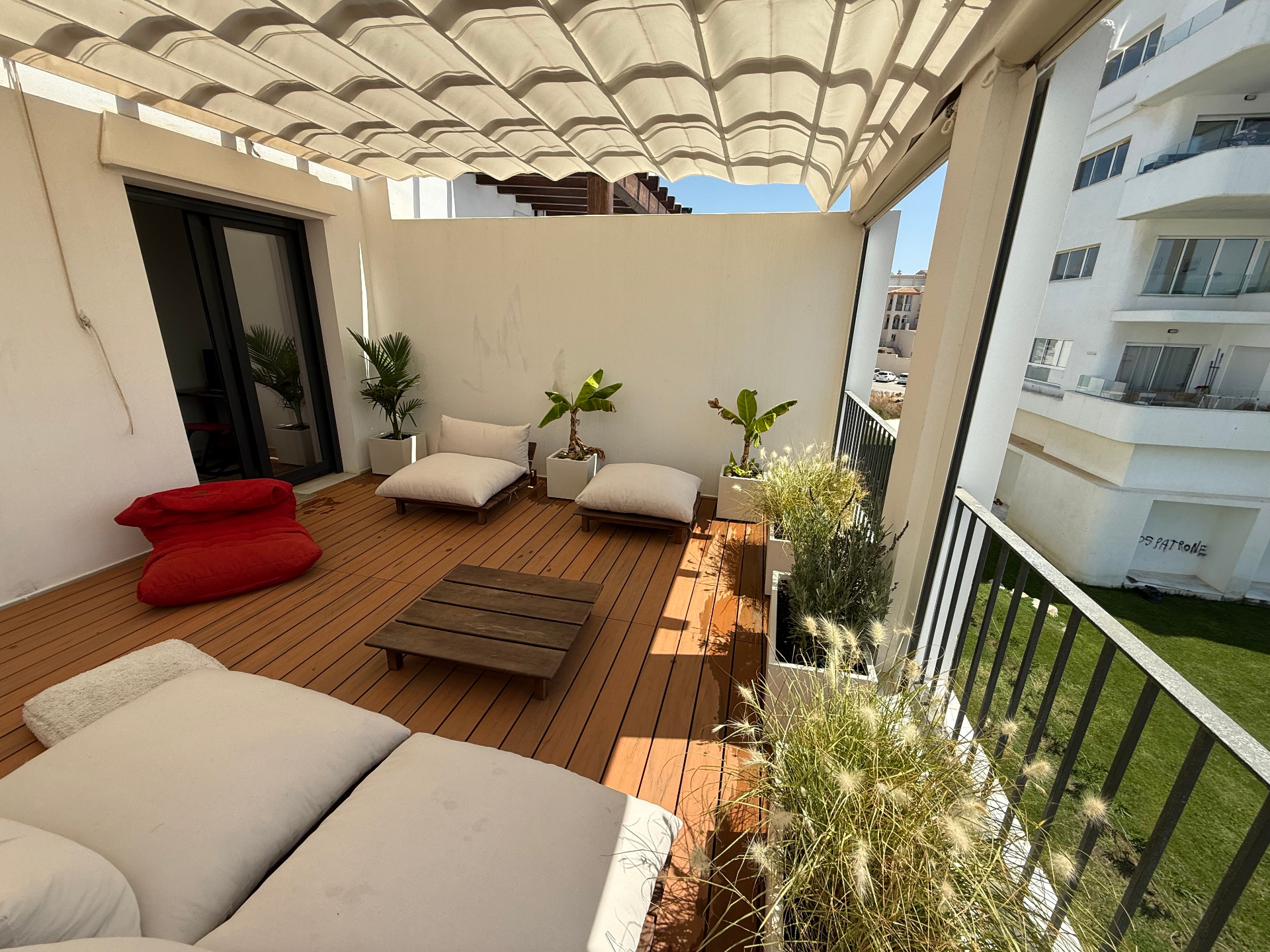 Sonnige Dachterrasse mit Holzboden und Blick auf die Küste von Tarifa
